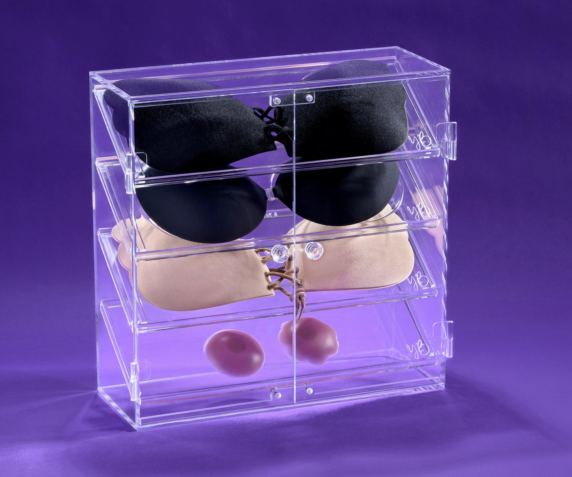 Clear acrylic bra display case on a purple background